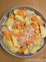 Курица с овощами: Очистить морковь, нарезать кружочками.   Очистить лук от шелухи и нарезать полукольцами. Добавить овощи в форму.
