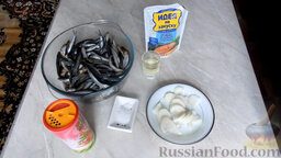 Хамса, запечённая в духовке: Подготовить ингредиенты для хамсы, запеченной в духовке. Вымыть рыбу и нарезать лук полукольцами.