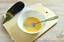 Острые баклажаны в панировочных сухарях: Взбиваем яйцо со специями и чесноком при помощи вилки.