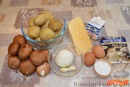 Картофельная запеканка с грибами и сыром: Подготовить ингредиенты для картофельной запеканки с грибами и сыром.   Картофель отварить в кожуре, до полуготовности, остудить и очистить. Нарезать шампиньоны. Раздавить чеснок. Нарезать лук. Натереть сыр на крупной терке.