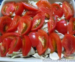 Запеканка из пельменей: На пельмени высыпьте лук и чеснок, сверху выложите помидоры. Посыпьте солью, перчиком и травами.