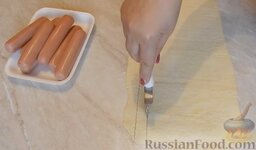 Сосиски в слоеном тесте "Забавные малыши": Разрезать тесто на тонкие полоски.