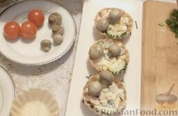 Тарталетки с салатом из ветчины и сыра, с грибами и помидорами: Украсить тарталетки огурцами.   В каждую тарталетку положить по 2 маринованных шампиньона.