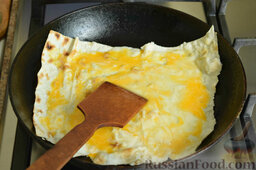Конвертик из лаваша c кабачками и сыром: Разбить яйцо над лавашем, лопаткой размазать по периметру.