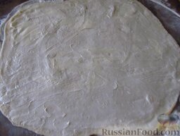 Фытыр по-египетски (слоеный пирог с заварным кремом): Разделите тесто на две равные части. Каждую часть раскатайте в пласт толщиной около 5 мм. Смажьте мягким маслом.