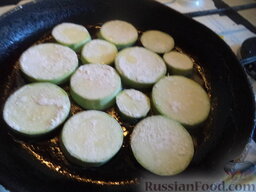Жареные кабачки с чесноком и сметаной: Разогреть сковороду, налить растительное масло (2 ст. ложки). В горячее масло выложить кабачки.