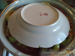 Болгарский перец, фаршированный рисом и грибами: Накрыть тарелкой, довести до кипения. Убавить огонь. Накрыть крышкой, варить фаршированный перец на небольшом огне до готовности (около 45-50 минут).