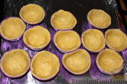 Пирожные "Корзиночки" с вишней и клубникой: Формы для кексов смазать маргарином и выложить в них тесто.