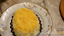 Слоеный салат "Березка": Сверху посыпать желтками.  Обложить салат маслинами.