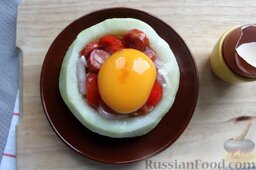 Кольраби с колбаской, томатами и яйцом: Разбиваем яйцо над нафаршированной капустой.