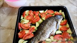 Карп, запеченный в духовке, с овощами: Выложить карпа на смазанный растительным маслом противень. Кабачки посолить и выложить вокруг рыбы, туда же поместить помидоры.