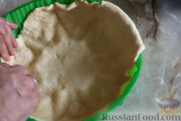 Дрожжевой пирог с творожно-тыквенной начинкой: Разделить тесто на 2 части. Часть теста раскатать в пласт и поместить в форму для выпечки. (Если форма не силиконовая, то ее необходимо смазать растительным или сливочным маслом.)