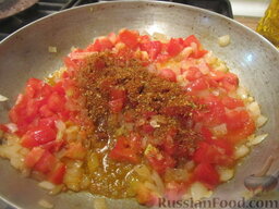 Куриные сердечки в горшочках, с овощами: К томатам с луком и чесноком добавляем специи. Перемешиваем.