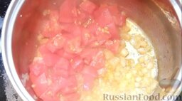 Рыбный суп буйабес: Добавить в кастрюлю с пассерованным луком вино. После выпаривания спирта добавить помидоры. Оставить на огне на 2 минуты.