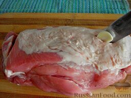 Буженина в домашних условиях: В куске мяса сделать надрезы, заполнить их чесночком.