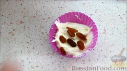 Маффины с арахисом: Формы для кексов смазать сливочным маслом. Половину формы наполнить тестом, затем положить в середину изюм.