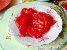 Остренькие баклажаны в аэрогриле: Снимите кожуру с помидоров. Если она плохо снимается, то сначала обдайте помидоры кипятком. Очищенные томаты нарежьте круглыми пластинками или полукружиями толщиной 0,5 см.