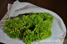Салат "Цезарь" слоеный с креветками и крабовыми палочками: Сполоснуть в холодной воде листья салата. Обсушить с помощью полотенца.