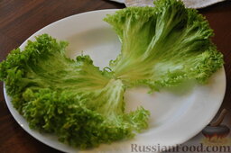 Салат "Цезарь" слоеный с креветками и крабовыми палочками: Выложить листья салата на блюдо.