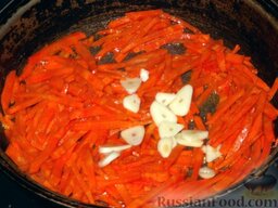 Кролик в сметане: Выложить чеснок на сковороду и пассеровать вместе с морковью на сливочном масле, помешивая,  еще 5 минут.