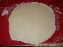 Торт «Наполеон» (способ 2): Через 30 минут достать одну порцию теста. Раскатать ее в круг толщиной 2-3 мм. Обрезать края с помощью тарелки или другой формы. Края убрать в сторону.