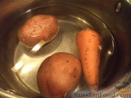Салат «Гранатовый браслет»: Помыть картофель и морковь, выложить в кастрюлю, залить холодной водой. Поставить на огонь, довести до кипения, варить на среднем огне до готовности (около 20 минут). Охладить.