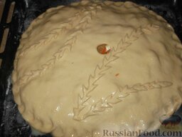 Пирог с капустой: Накройте пирог второй лепешкой и защипните края. Украсьте пирог.  Взбитым яйцом (или смесью желтка и воды) смажьте поверхность пирога с капустой, сделайте отверстие сверху для выхода пара.