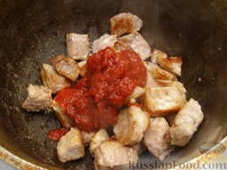 Гуляш из свинины со сметаной: Обжаренную свинину положить в кастрюлю (а лучше в казан) с пассерованным томатом-пюре.