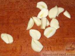 Толстолобик с рисом к Новогоднему столу: Очищаю головку чеснока. Крупные зубчики разрезаю пополам, поперек или вдоль.