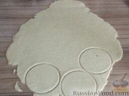 Печенье домашнее с творогом: Стол застелить пищевой пленкой.  Выложить тесто. Раскатать его в пласт толщиной 5 мм, вырезать кружки, диаметром 6-8 см