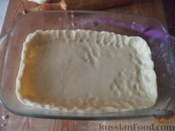 Чешский пирог со сливами: Тесто выложите на противень. Края лепешки смажьте яйцом (взбитым желтком) и сделайте из теста бортики.