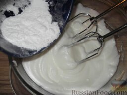Белковый крем: Когда масса станет белой и плотной (примерно через 10 минут), продолжать взбивать, постепенно добавляя сахарную пудру.
