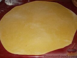 Казахский пирог чак-чак: Стол посыпать мукой.    Подготовленное вылежавшееся тесто разделить на несколько небольших кусков. Каждый кусок раскатать в пласт толщиной 2—2,5 мм