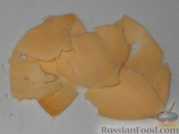 Рулетики из куриной грудки с грибами: Сыр нарезать тонкими пластинами.    Сыр лучше брать без особо выраженного вкуса, например российский, иначе он перебьет вкус грибов и зелени.
