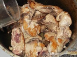 Курица, тушеная в сметане: Переложить обжаренные кусочки курицы в чугунок, залить горячей водой (треть стакана), накрыть крышкой и поставить тушить на 35-40 минут.