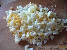 Салат из сыра, яиц и редиса: Сваренные вкрутую яйца очистить, отложить четверть яйца, а остальное мелко порубить.