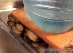 Баклажаны консервированные: Если плоды отварные, то выложить их на доску с грузом сверху, чтобы стекла вода.