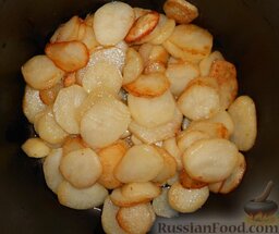 Картофель, тушенный с печенкой: Сложить в кастрюлю ряд обжаренного картофеля.