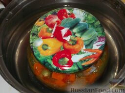 Салат из стручковой фасоли и моркови: Накрыть чистыми крышками и поставить в кастрюлю с горячей водой. Стерилизовать салат с фасолью и морковью в течение 7-10 мин, закрыть, перевернуть вверх дном и оставить до остывания.