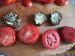 Баклажаны с помидорами и чесноком: Положите на каждый кружочек баклажана чеснок и кружок помидора.