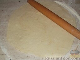 Курник из песочного теста: Включить духовку.    Охлажденное тесто разделить на 2 части в соотношении 1:2. Из большей части теста раскатать лепешку толщиной 0,4-0,5 см